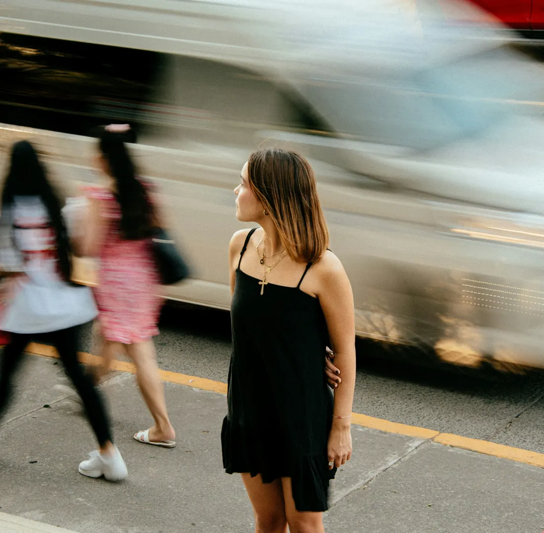 Woman in a black dress at a busy crosswalk