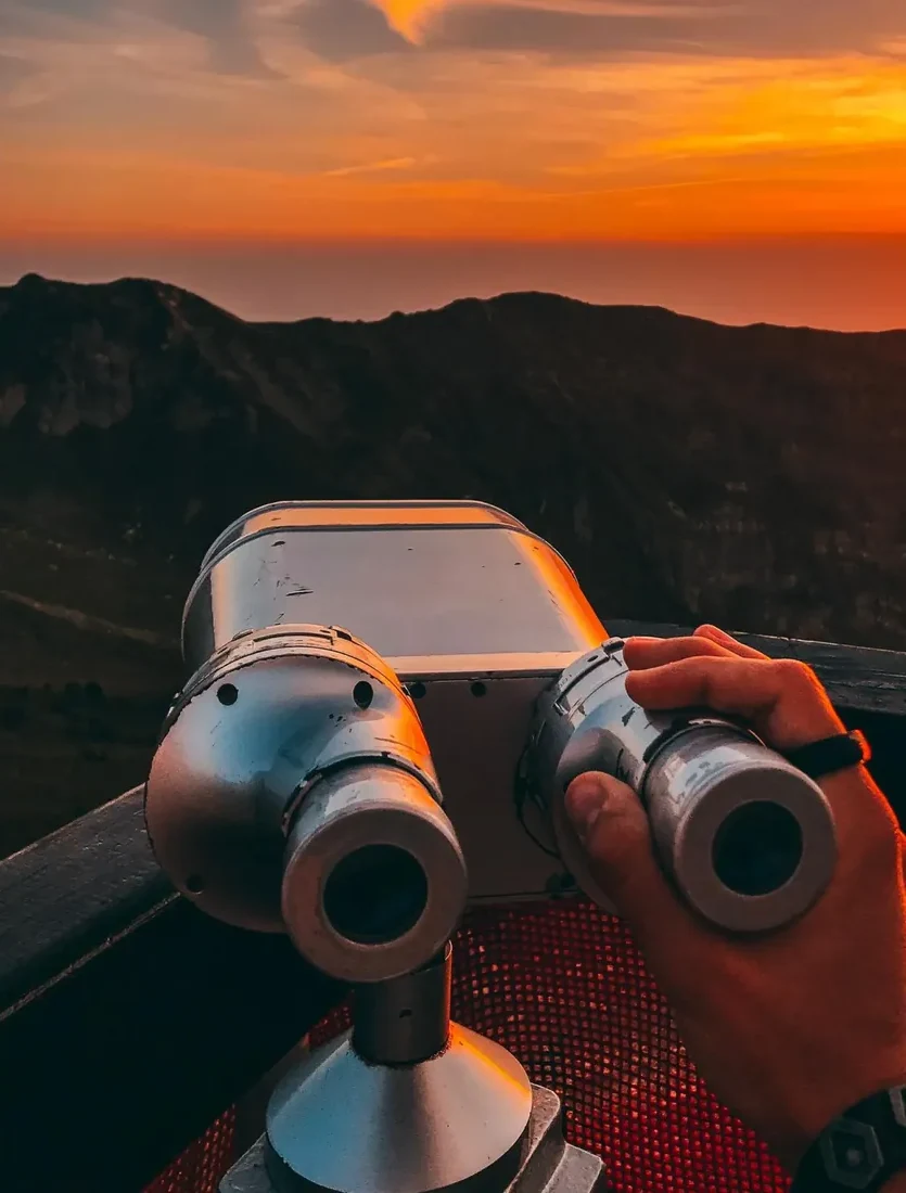 Coin binoculars at a mountain viewpoint at sunset