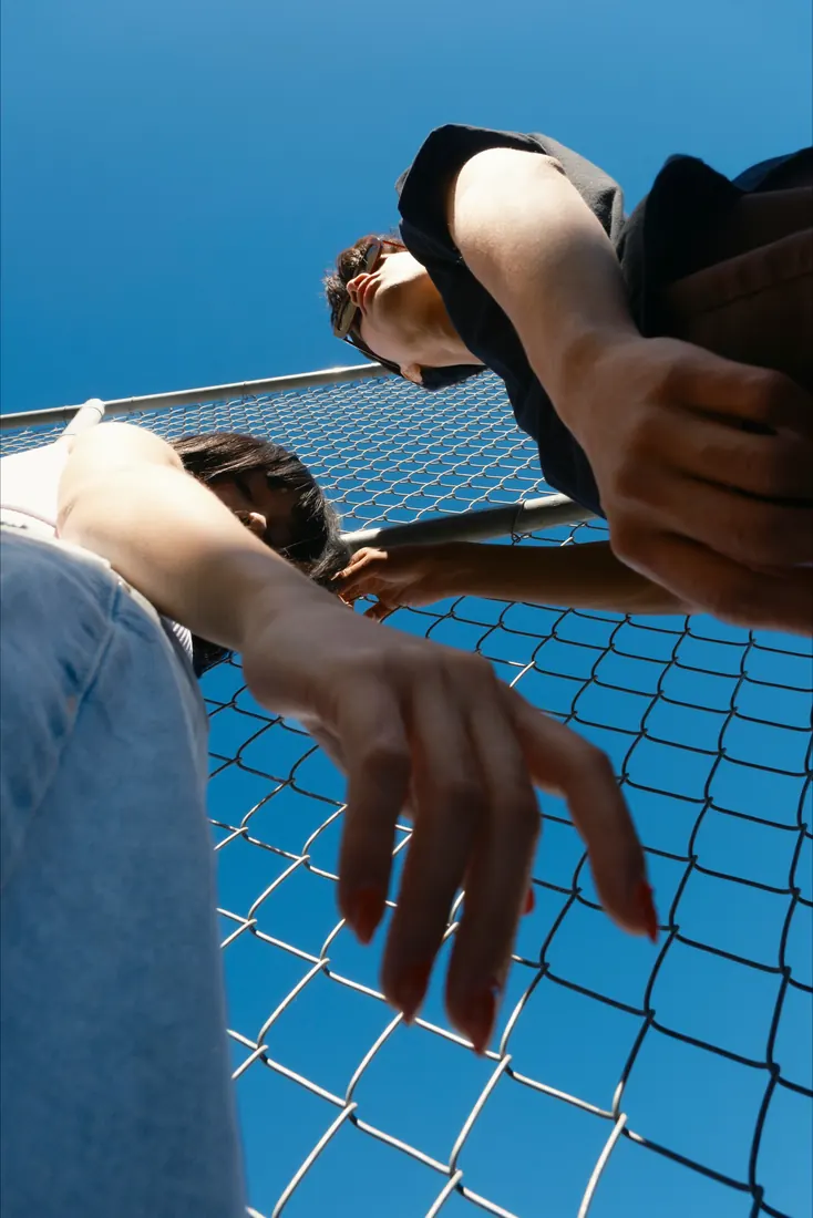 Friends looking up against a bright blue sky